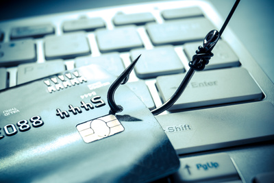 Photo of a laptop with a credit card and a fish hook to represent phishing scams